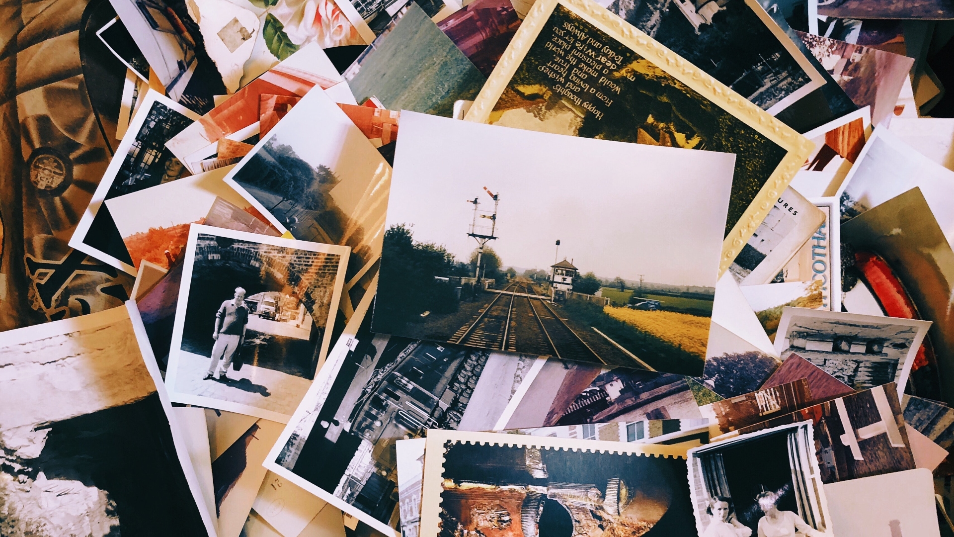 A pile of photographs. The photographs are mostly old photographs of historic scenes.